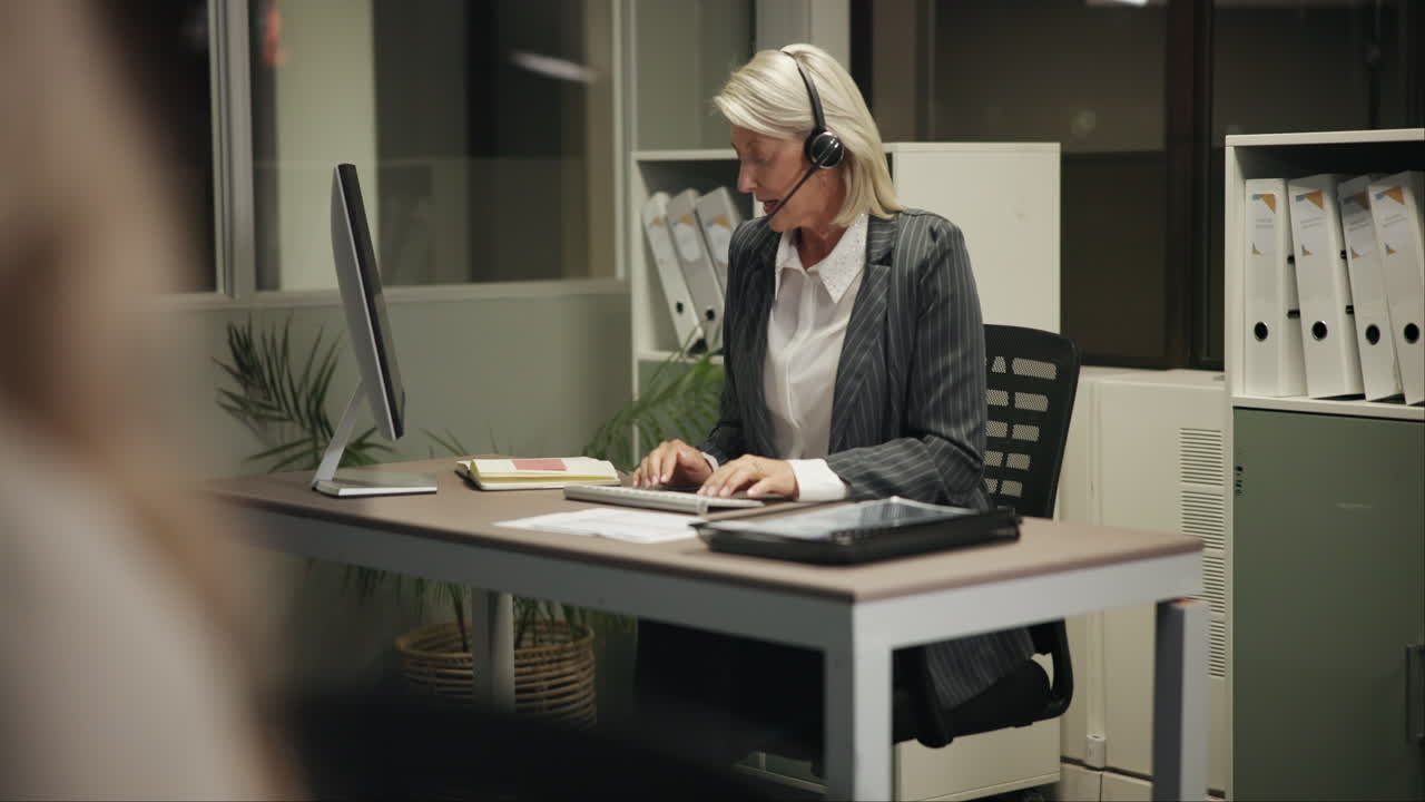 Woman with Headset Working at Desk in Office