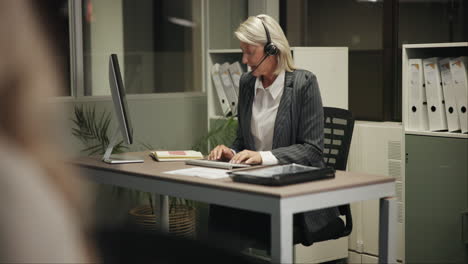 woman with headset working at desk in office