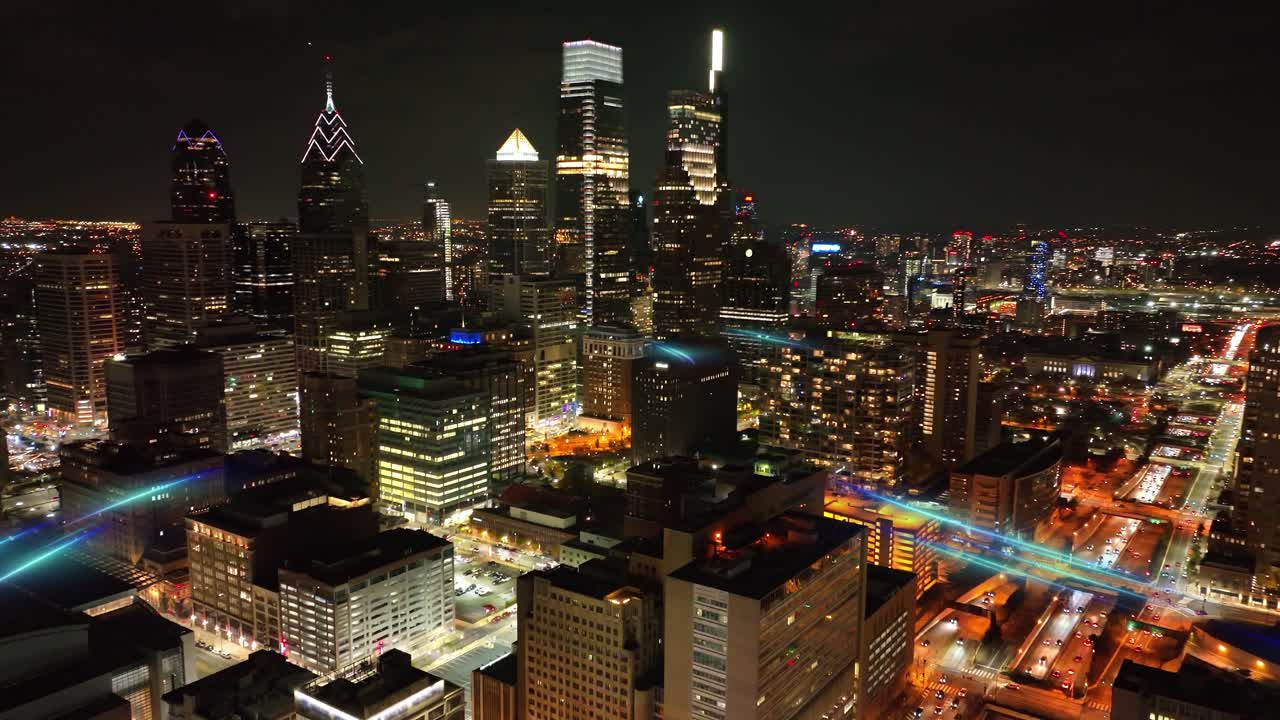 Major U.S. city skyline enhanced with flowing digital light paths representing data movement, connectivity, and futuristic urban network. Aerial dolly forward towards dark skyscrapers at night
