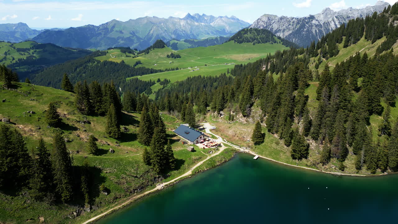 Aerial: Lake Lioson during the day with valley in Ormont-Dessous, near Les Mosses, in the canton of Vaud, Switzerland, push in drone shot