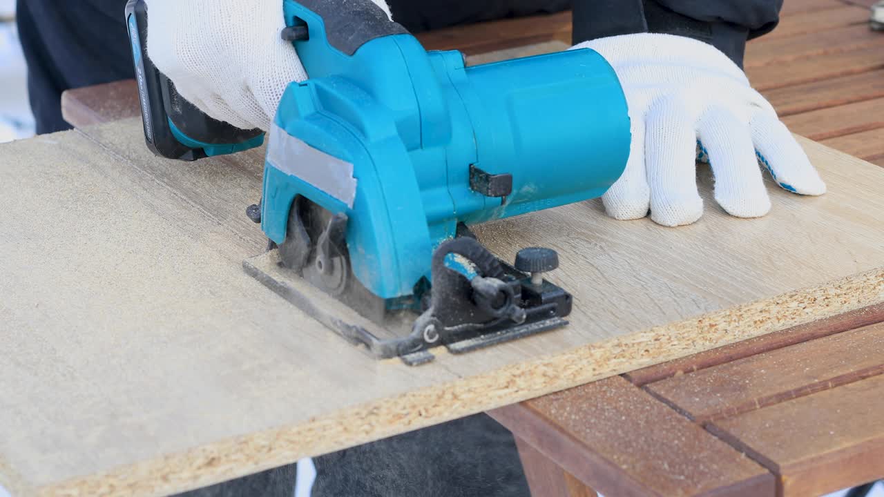 se corta el panel de madera con una herramienta eléctrica