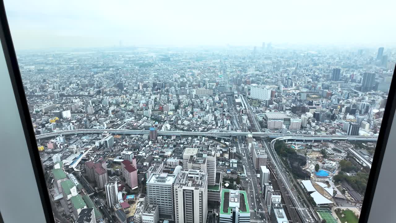 Elevated view of Osaka urban area featuring buildings, roads, and elevated highways, as seen from Abeno Harukas skyscraper