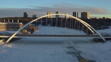 sunset white winter walter dale bridge aerial hold facing east with an icy snow covered north saskatchewan river with hardly any cars headed one way north to the downtown capital city of edmonton 1-4