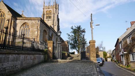 Panorámica-Lenta-De-Una-Iglesia-A-Una-Pequeña-Y-Pintoresca-Calle-Inglesa-En-Una-Tarde-Clara