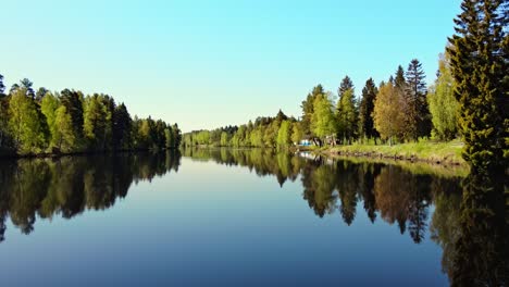 árboles-Frondosos-Reflejo-En-El-Agua-Transparente-Del-Río-Vasterdalalven-En-Vansbro,-Condado-De-Dalarna,-Suecia