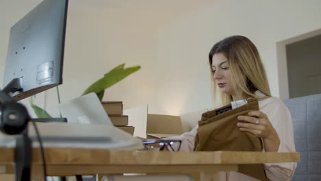 young caucasian woman checking clothing label and putting inside a cardbox