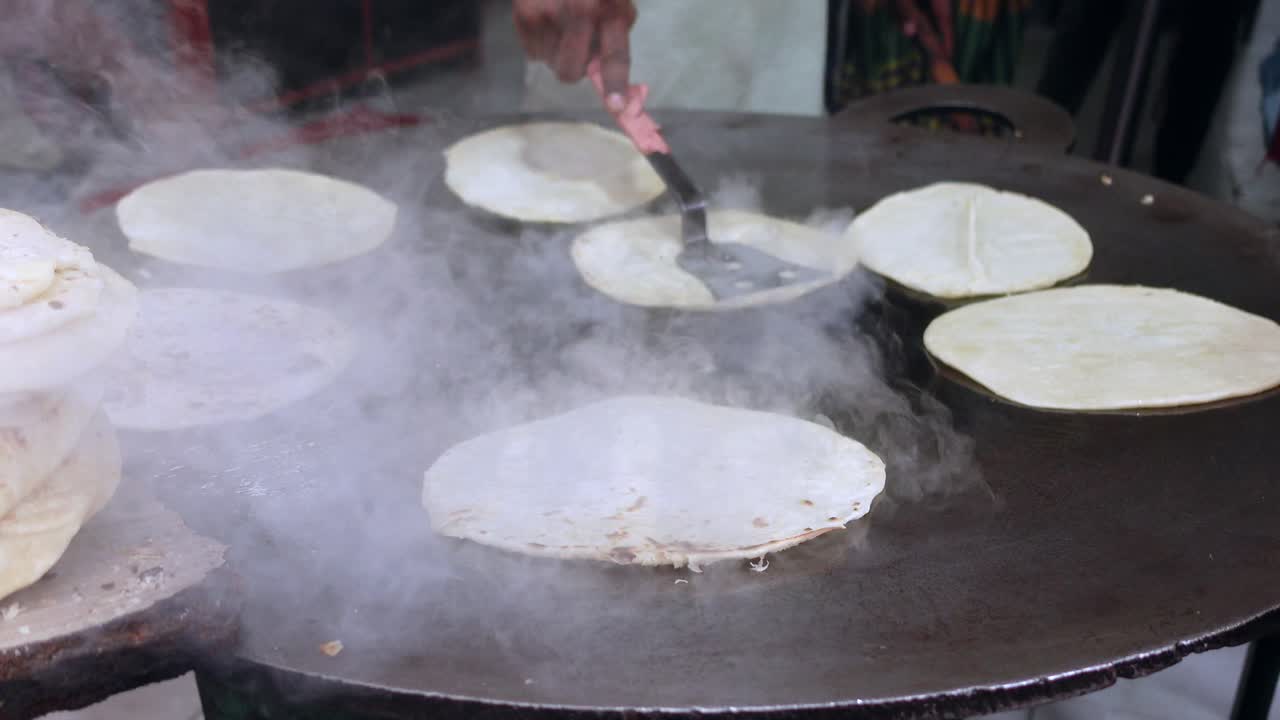 haciendo chapati en un puesto de comida callejera