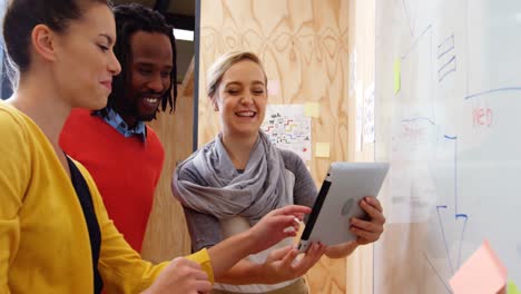 business executives discussing over digital tablet in office