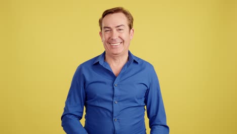 Man in blue shirt making various expressions and gestures on a yellow background