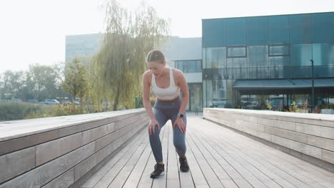 athletic runner woman in sportswear with muscle pain after jogging in urban city park on sunny day