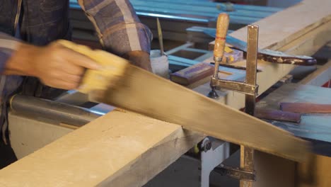 the carpenter cuts wood in the workshop.