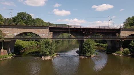 vuelo aéreo a través de la toma de un puente de tren de piedra dentro de la exuberante naturaleza de alemania occidental en primavera