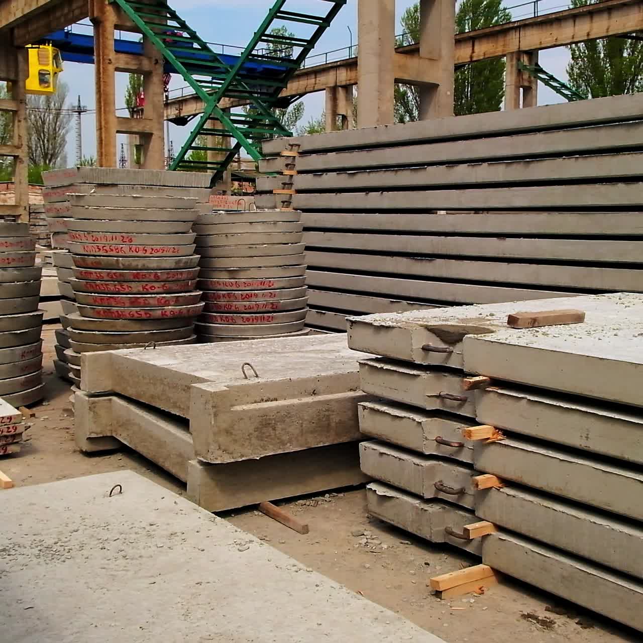 Reinforced concrete materials of diverse shape and size. Metal supports, ladders and cranes for lifting bricks and blocks