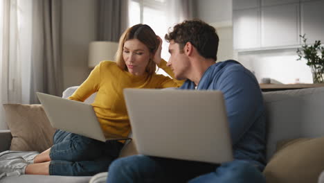 young couple cooperating computers at living room closeup. colleagues working