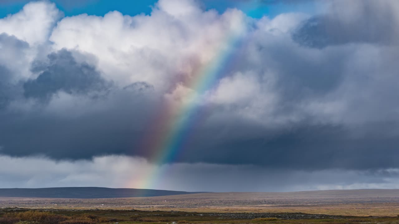 arco iris de colores brillantes en los cielos tormentosos sobre el desolado paisaje de la tundra
