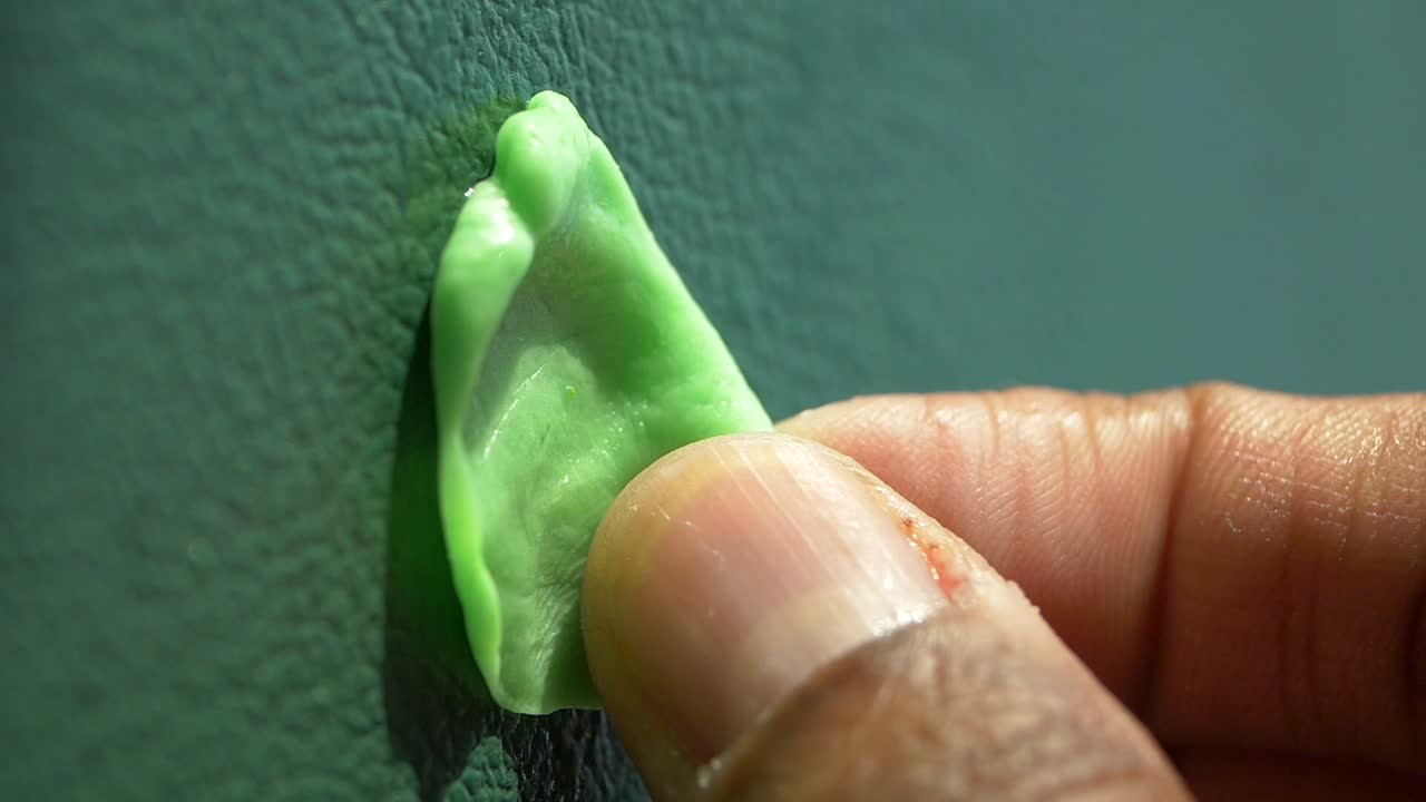Green chewing gum stuck to a textured wall