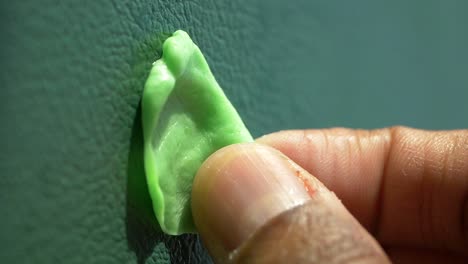 green chewing gum stuck to a textured wall