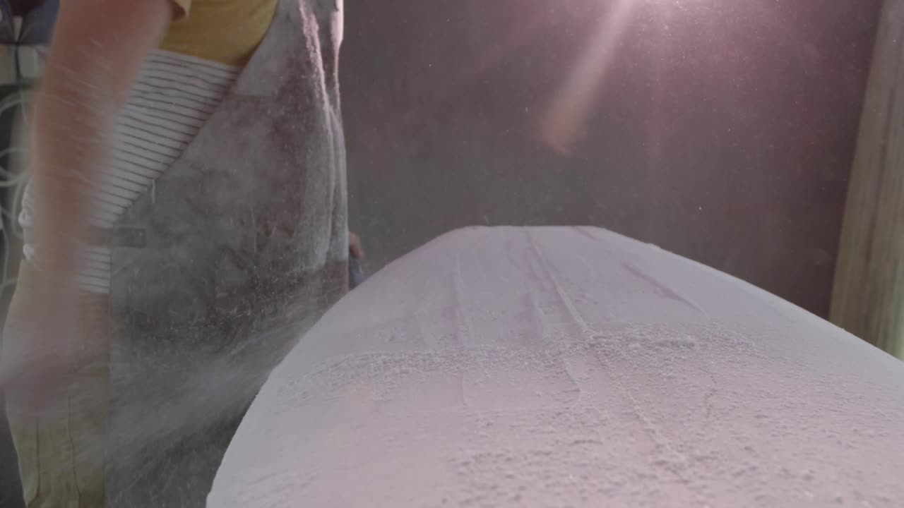 un hombre que hace tablas de surf en su taller