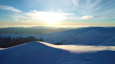 flight over the snowy mountains illuminated by the evening sun