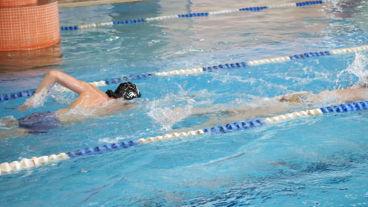 실내 수영장 에서 수영 하는 사람 들