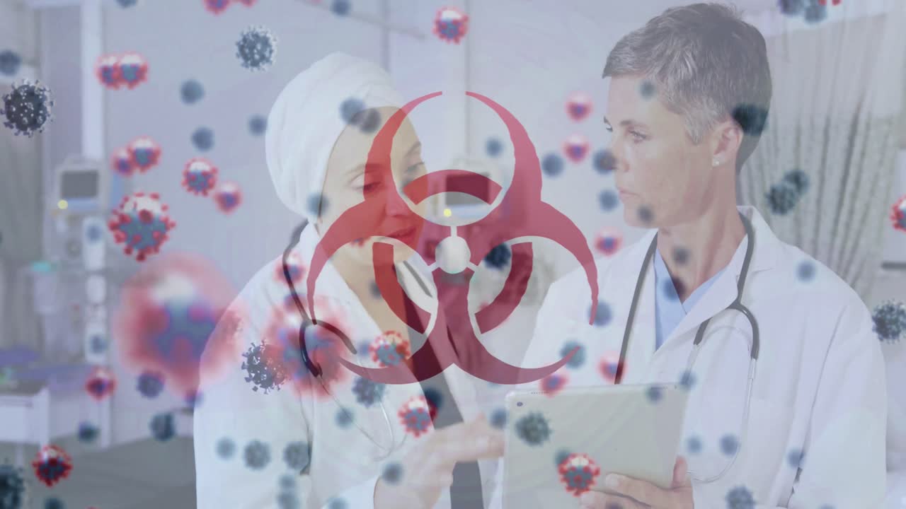 символ биологической опасности и клетки covid-19 против двух женщин-врачей, обсуждающих