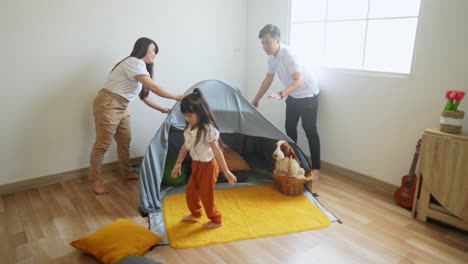 excited asian family making tent at home with cloth