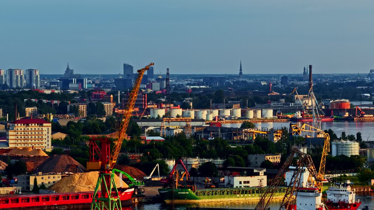Aerial of city skyline contrasted with waterfront cranes and marine transport industrial buildings and boats in harbor