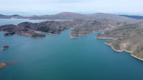 imágenes aéreas cinematográficas lentas del lago plastira en el centro de grecia durante una tarde de primavera | 4k