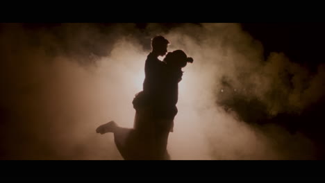 couple silhouettes in night fog