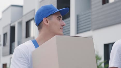 two young workers of removal company deliver boxes to a customer's home