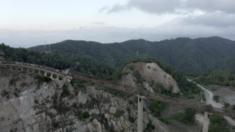 Aerial-View-Over-Abandoned-Cuarry-Sant-Feliu-De-Llobregat-Conveyor-Rail-Barcelona,-Spain-Pull-Away