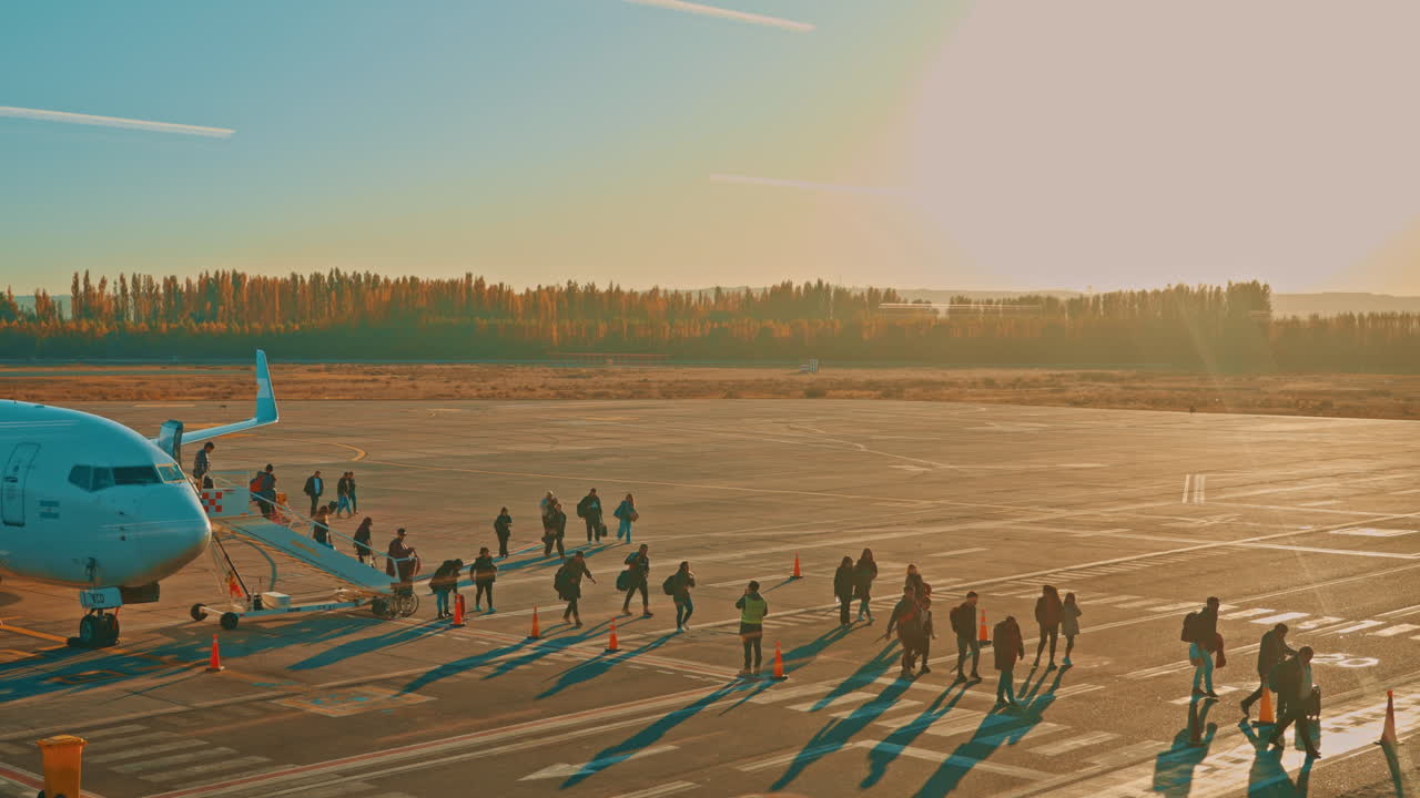 Passengers Boarding or Disembarking an Airplane on a Sunny Airport Tarmac