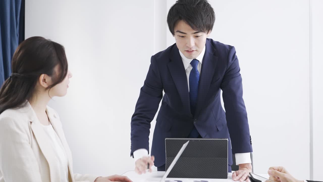 아시아 사업가 한 명이 회의에서 설명하고 있다.