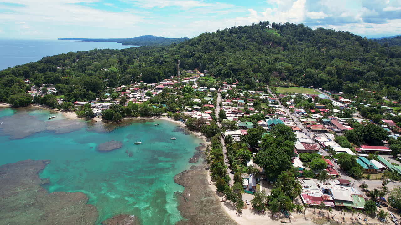 An aerial over downtown Puerto Viejo, a tropical Central American travel destination in Costa Rica, with coral reefs and fishing boats in the turquoise water of the scenic surrounding beaches.