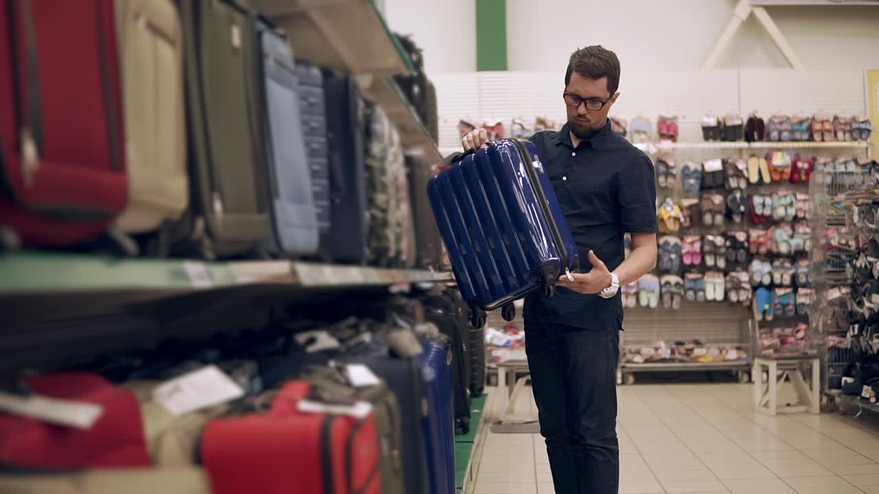 Uomo che compra valigie in un negozio
