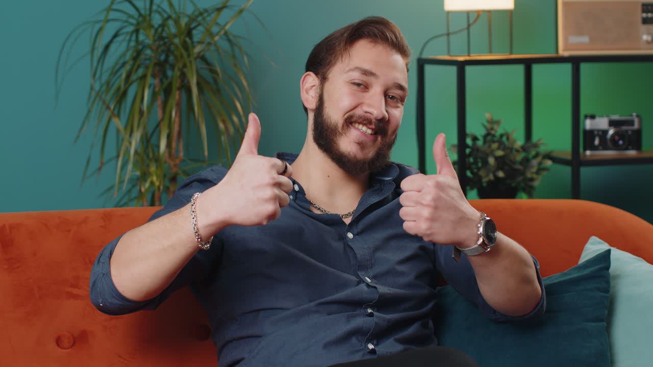 Happy lebanese man looking approvingly at camera showing thumbs up like positive sign good news