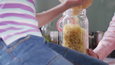 Close-up-of-caucasian-family-unpacking-bags-with-pasta