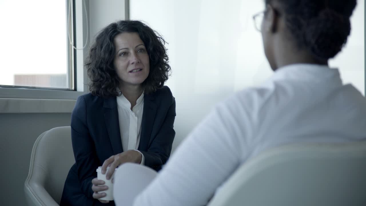 Imprenditrici sorridenti che parlano in ufficio