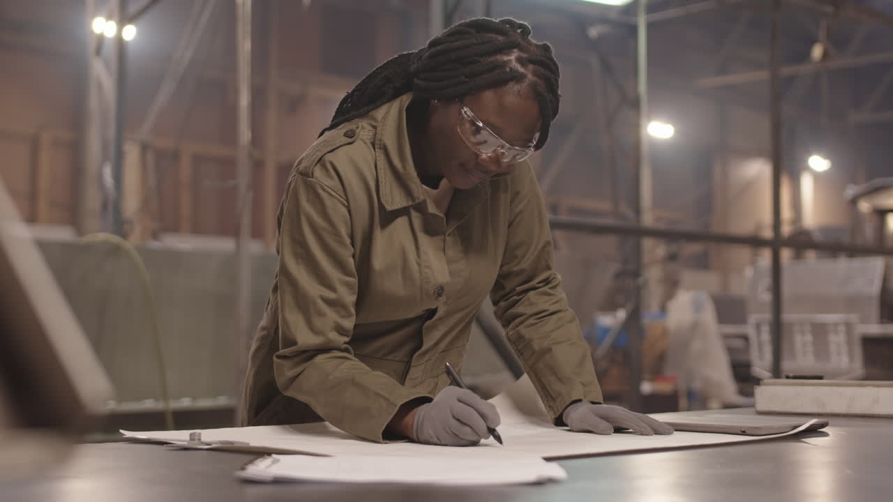 An engineer working on a blueprint in a factory