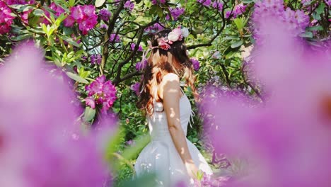 latvian woman dances in joy among rhododendrons in blooming garden near riga