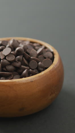 video de un cuenco de madera de trozos de chocolate sobre un fondo gris