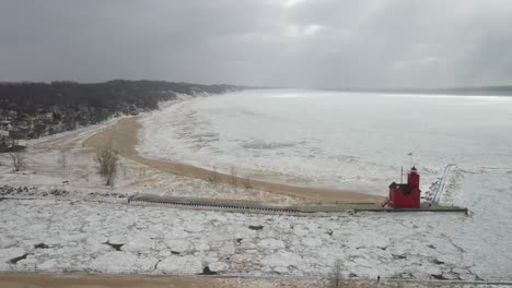 Holland,-Michigan-lighthouse-in-the-winter-at-Lake-Michigan-with-drone-flying-sideways