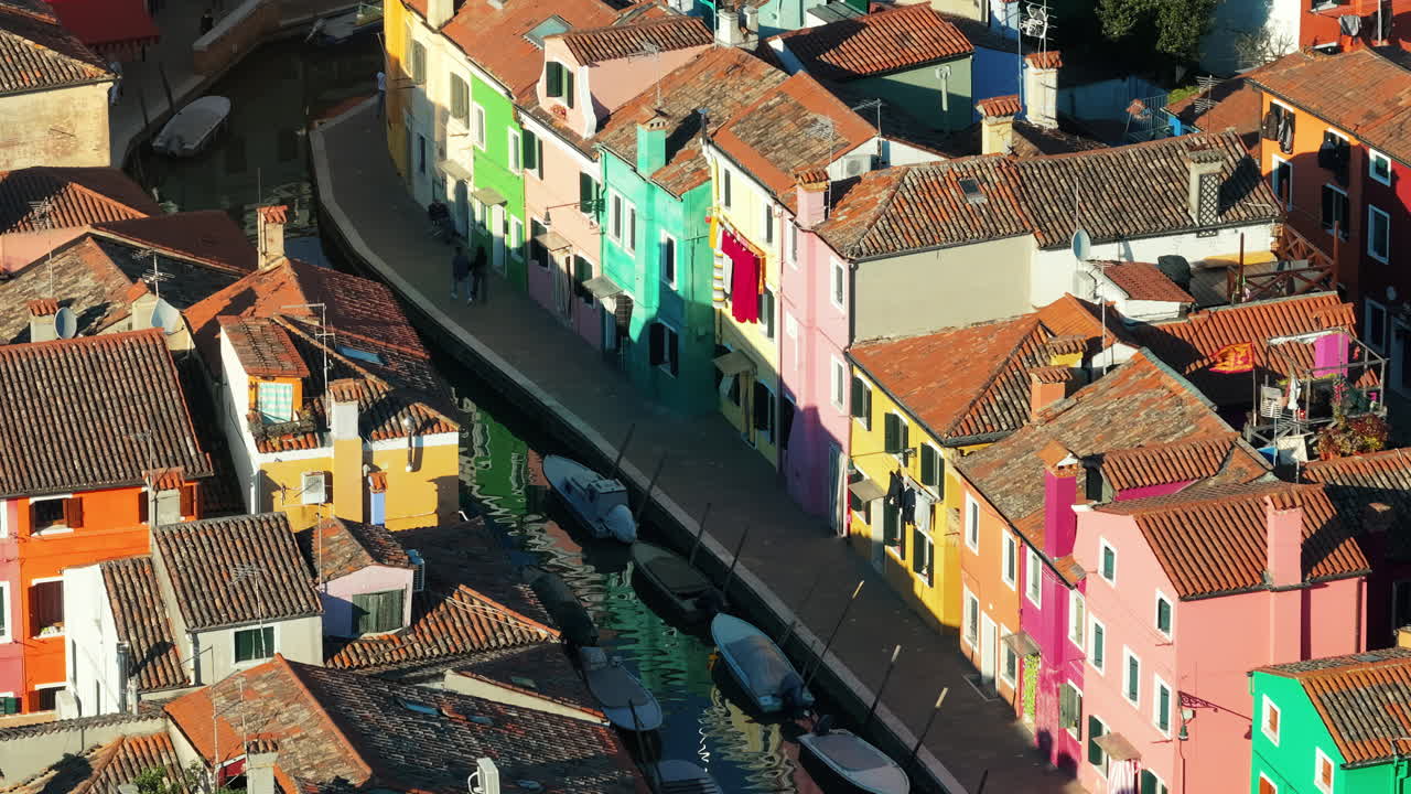 Aerial drone view of boats on the sides of a canal near the colourful houses of Burano Italy