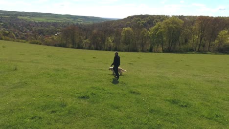 aerial shot of mature man with dog on walk in countryside