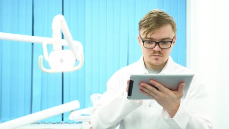 dentista que usa una tableta en el consultorio