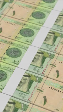 vertical video of 1 saudi riyal banknotes printing by a money press