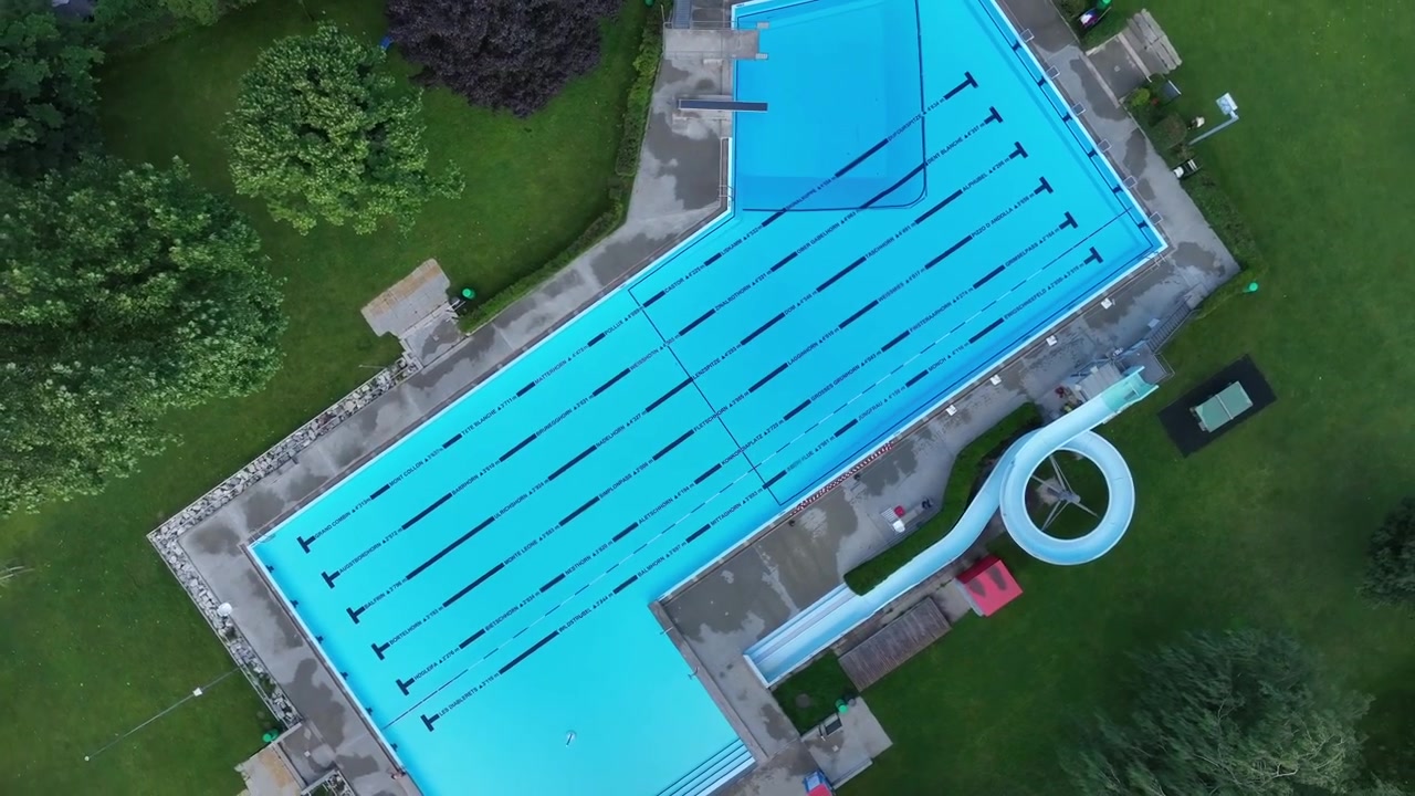 Forladt olympisk swimmingpool. Luftfoto fra drone direkte ovenfra med stigende bevægelse og vertigo-effekt.