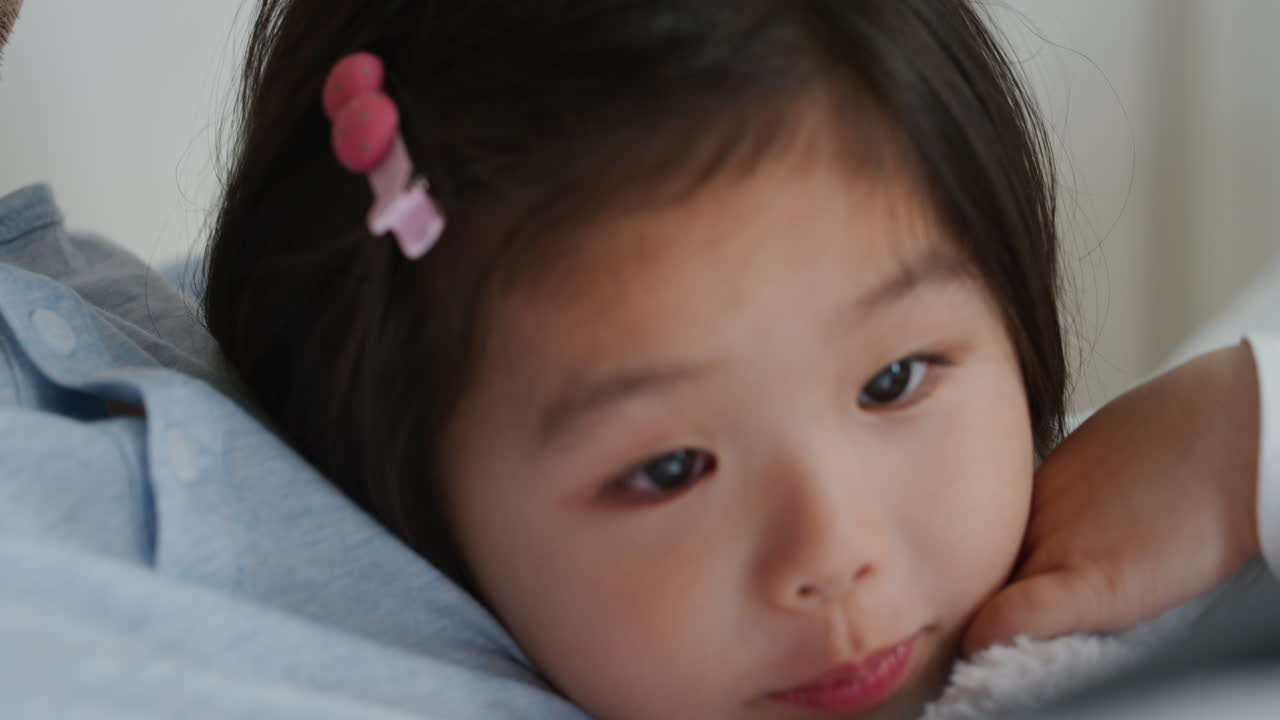 가족과 함께 태블릿 컴퓨터를 사용하는 귀여운 작은 아시아 소녀는 터치 스크린 장치에서 게임을 즐기고 집에서 함께 휴식을 취합니다 4k