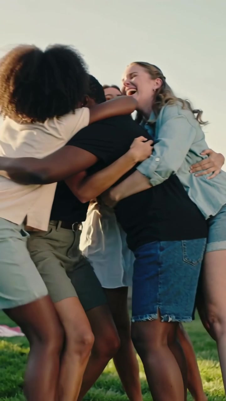 Vídeo vertical: Movendo-se de fora para dentro, adolescentes formando um abraço apertado no gramado perto da cerca, reencontrando-se