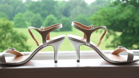 brides wedding shoes on the windowsill with a lovely view in the background